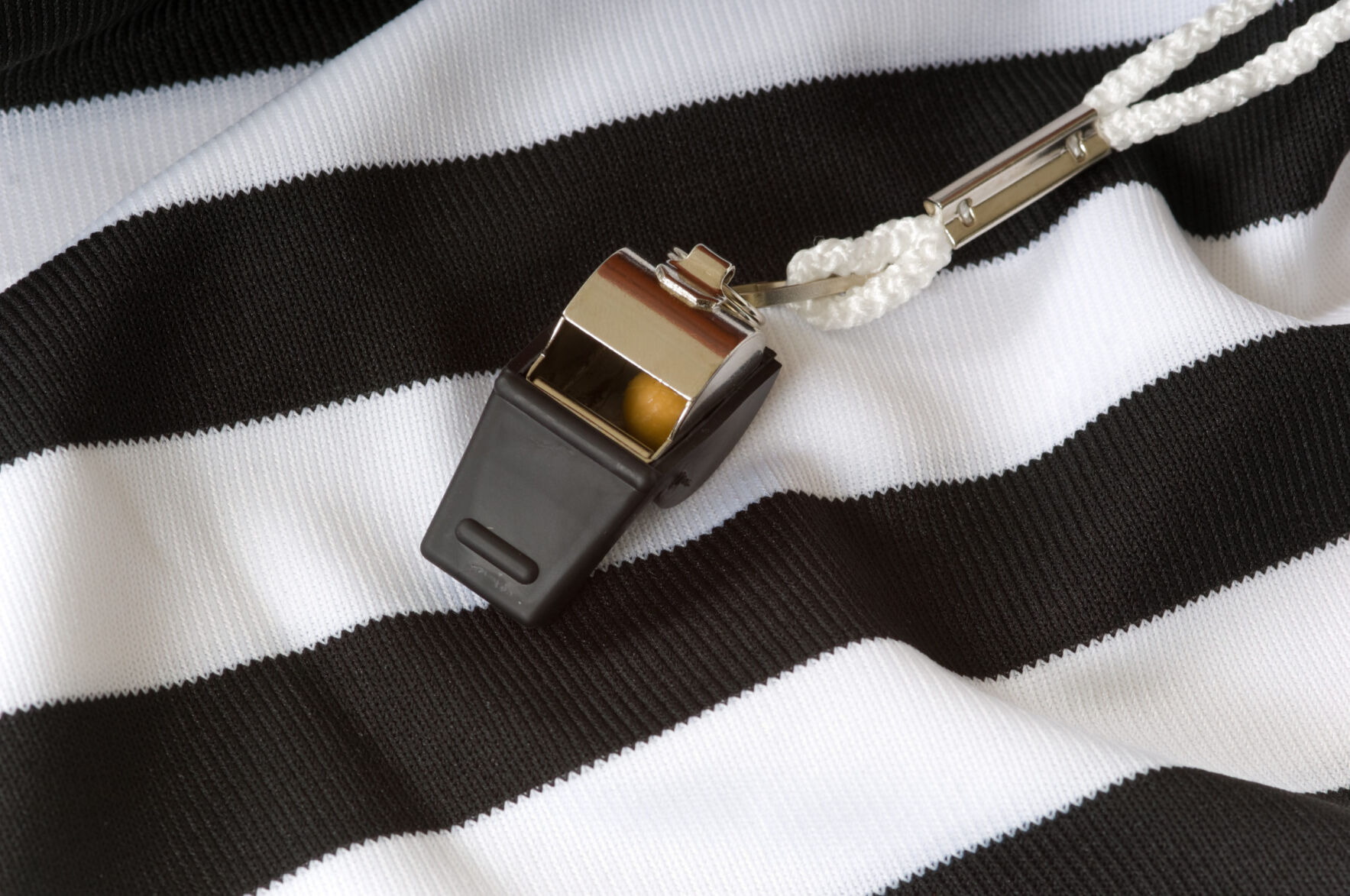 Whistle on a black and white striped referee shirt